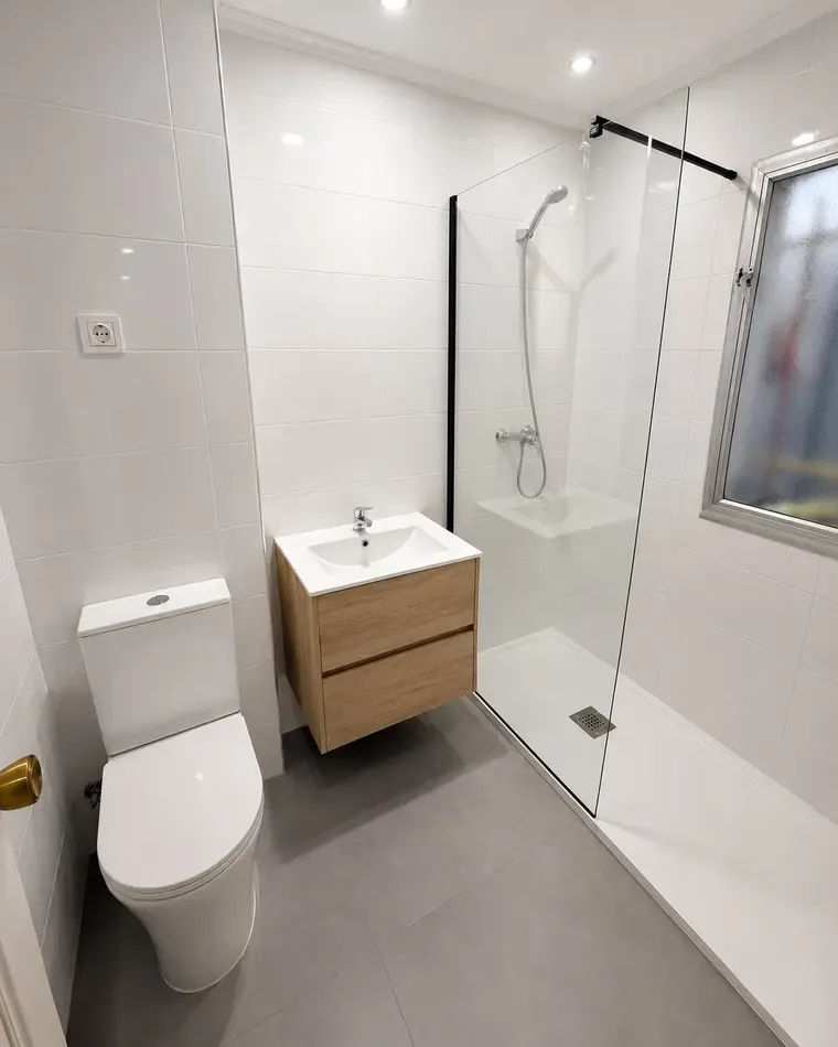 Baño reformado con plato de ducha y mampara fija