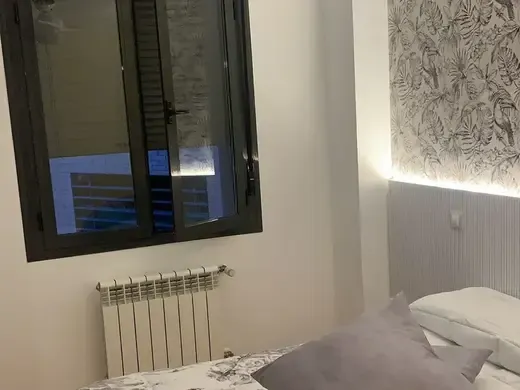 Dormitorio con una ventana y un estor ya colocado