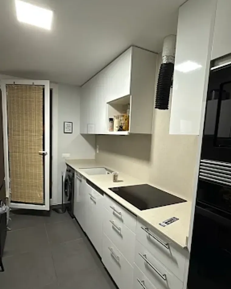 Cocina blanca reformada con columna de horno