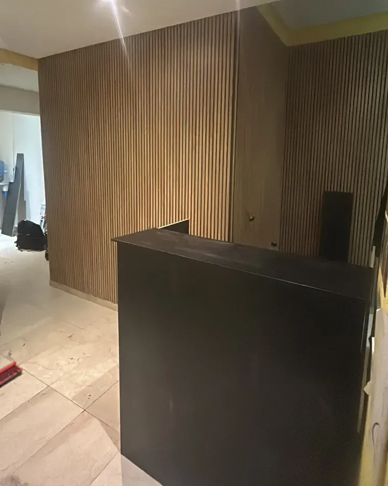 Mostrador de recepción con panelado de listones de madera
